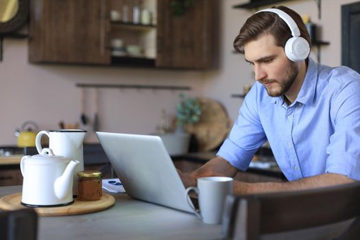 Confident man wearing headset speaking and watching business webinar training, listening to lecture