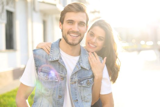 Beautiful young couple in love walking outdoors at the city street, hugging