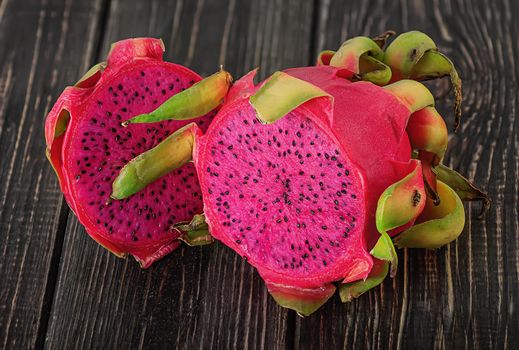 Two halves of dragon fruit on planks blurred background