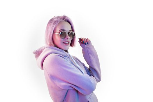 Fashion portrait of beauty young woman with pink bob hairstyle holding on to sunglasses blue nail polish manicure on white background