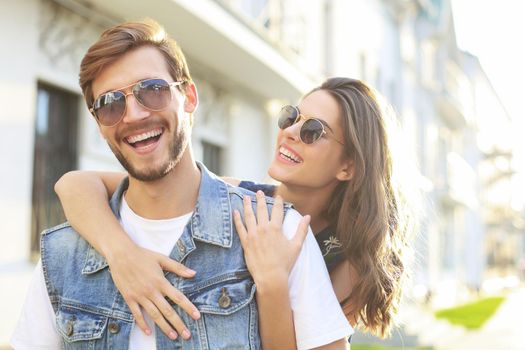 Beautiful young couple in love walking outdoors at the city street, hugging