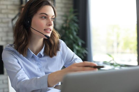 Freelance operator talking with headsets and consulting clients from home office