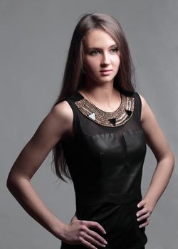 portrait of a confident young woman in a fashionable dress. isolated on grey background