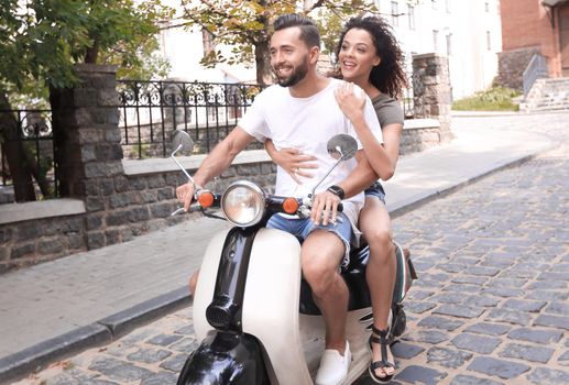 Portrait of happy young couple on scooter enjoying road trip