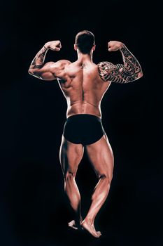 rear view. male bodybuilder showing his beautiful body.isolated on black background