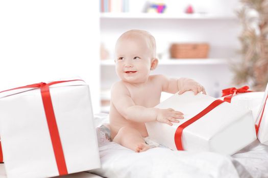 pretty baby plays with gift boxes