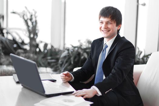 portrait of a young businessman on workplace in the office.