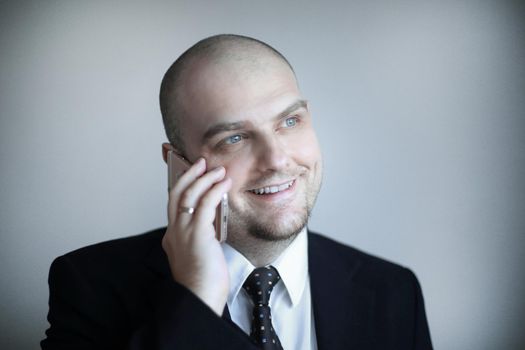 close up.confident businessman in a tie listens to the interlocutor on the phone.