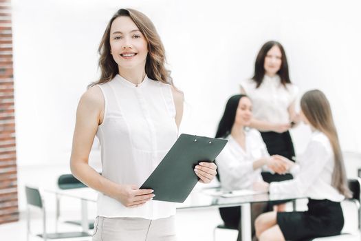 in full growth.successful business woman with clipboard on the background of business team.