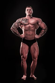 in full growth. handsome guy bodybuilder posing in front of the camera.isolated on black background