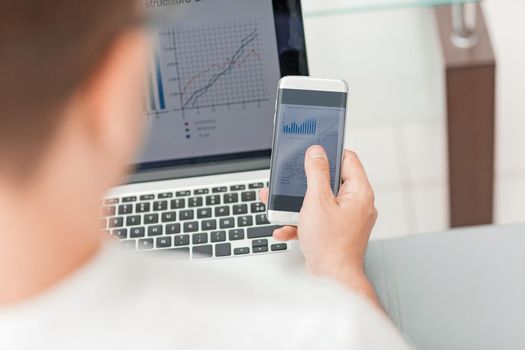 close up. businessman using gadgets for the audit of the financial report. people and technology