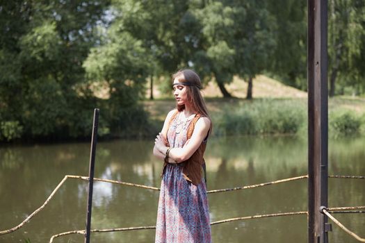young hippie woman standing on wooden bridge in Park . the concept of unity with nature