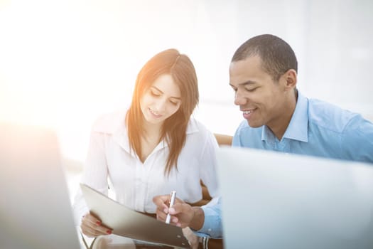 employees discussing financial documents sitting at a Desk .photo with copy space