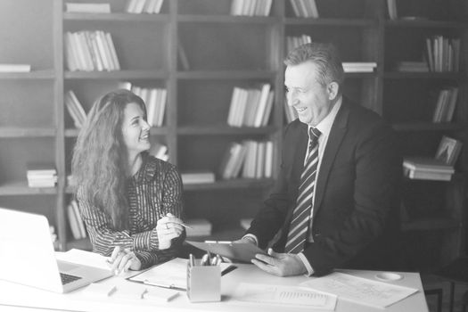 senior businessman and assistant discussing a working paper