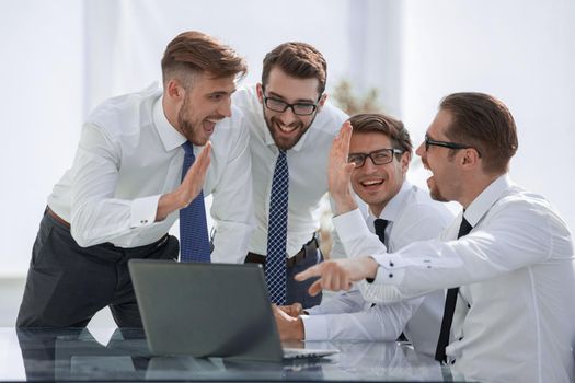 Happy excited team looking at the laptop screen.start-up