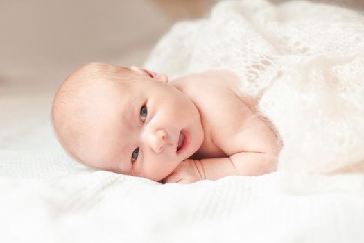 surprised newborn babe lying on the bed. photo with copy space