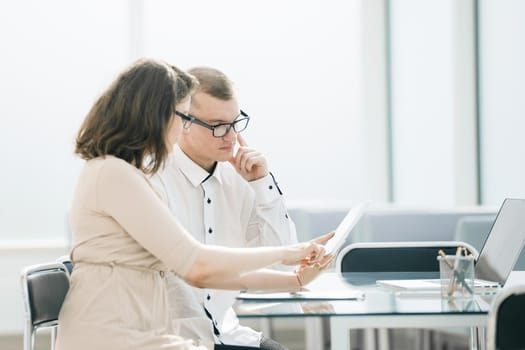 business colleagues use a digital tablet to work in the office. people and technology