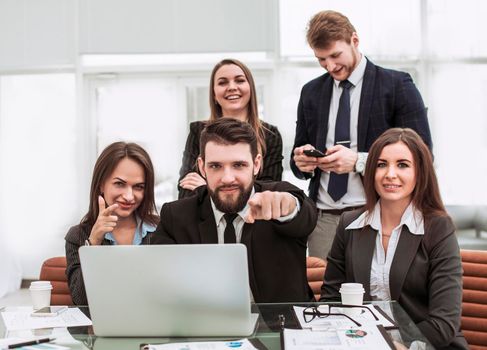 professional business team near the desktop, together showing forefinger forward
