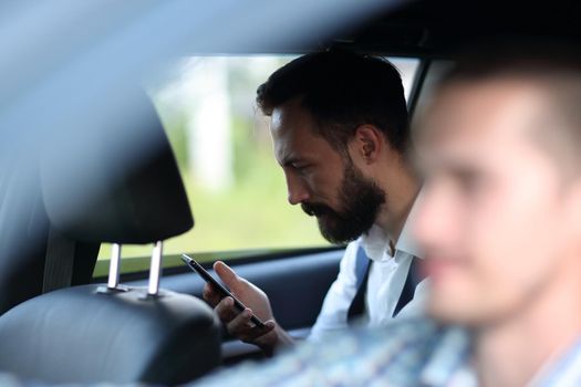 close up.business man looking at the screen of his smartphone . people and technology