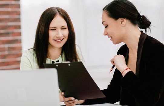 two business women discussing documents.