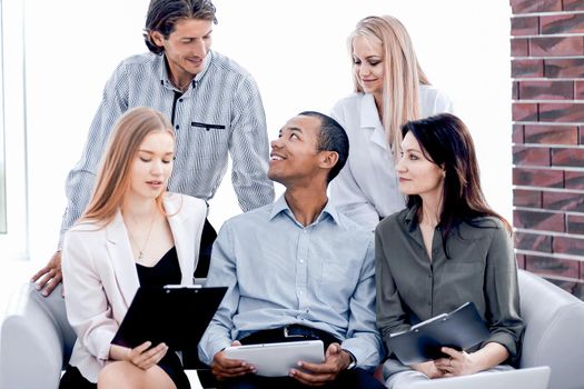 business woman and her business team discussing the data with a tablet computer.the concept of teamwork