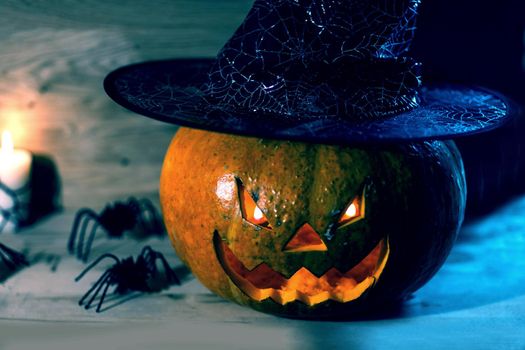 creepy pumpkin for Halloween in witch hat on wooden background .happy Halloween concept
