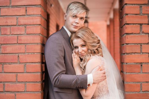 happy newlywed couple hugging each other while walking . holidays and events