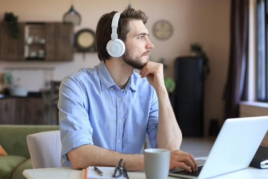 Confident man wearing headset speaking and watching business webinar training, listening to lecture