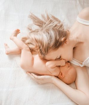 happy mom with newborn daughter lying on the bed . the concept of happy motherhood