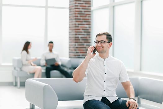 business man talking on a mobile phone in the lobby of the business center. business concept