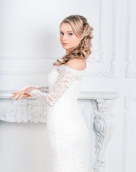 beautiful young woman in wedding dress standing in Bridal salon . holidays and events