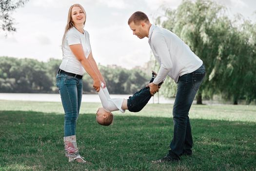 mother, father and play with their little son outdoors. the concept of active recreation