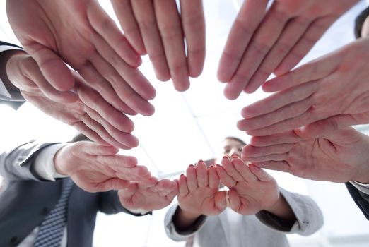concept of teamwork and unity. business team folding of the hands in a circle