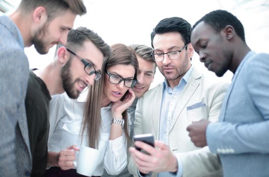 close up.business team, looking carefully at the smartphone screen