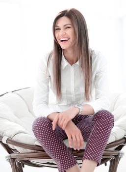 laughing young woman sitting in comfortable chair. lifestyle