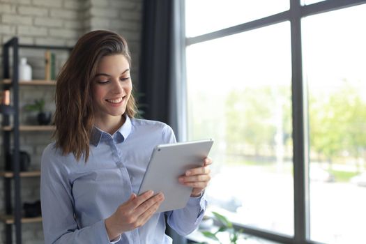 Attractive smiling woman working on a tablet in a home office
