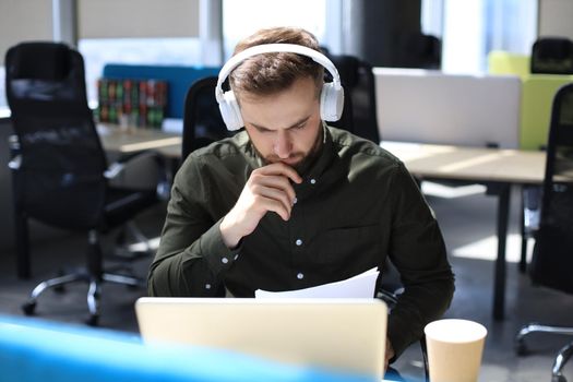 Successful entrepreneur is studying documents with attentive and concentrated look
