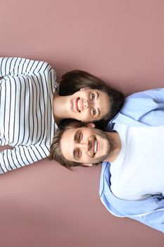 Top view portrait of smiling young couple lying relaxing on warm floor at home, happy family relaxing at home