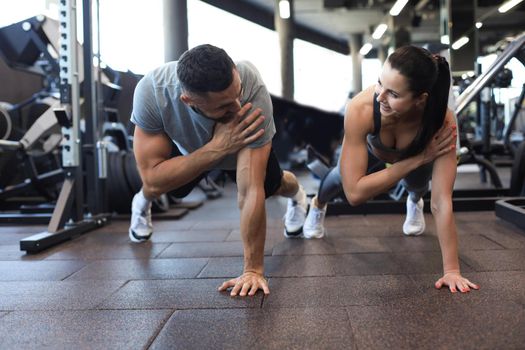 Portrait of beautiful young sports couple on a plank position