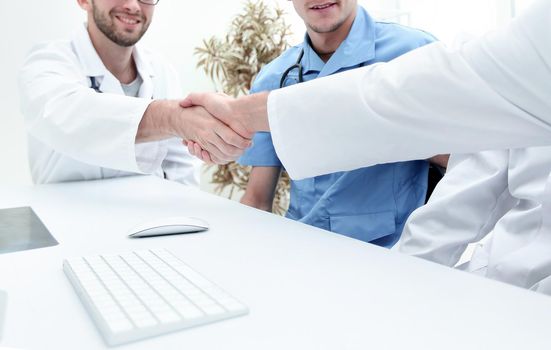 handshake between the two doctors during the working meeting in medical office