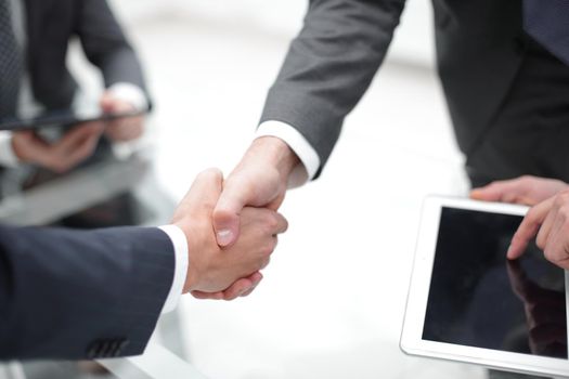 Two businessmen shaking hands during a meeting in the office.