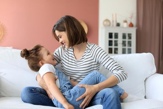 Happy loving mom hugging little daughter, spend time together at home