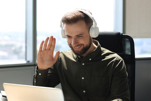 Smiling young business man having video call in office