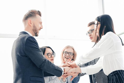business team showing their unity while standing in the office. the concept of teamwork
