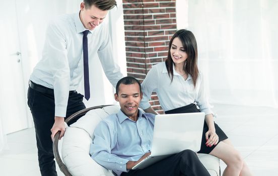 successful businessman with his assistants in a discussion of the information from the laptop.office life