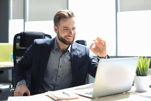 Smiling young business man having video call in office