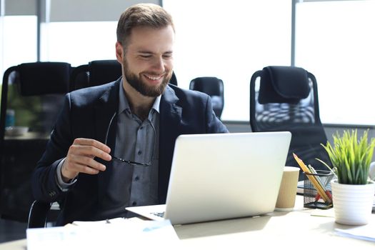Smiling young business man having video call in office