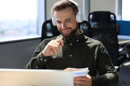 Smiling young business man having video call in office