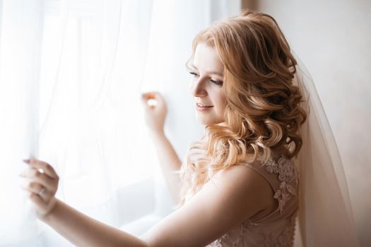 close up. young woman in wedding dress standing near the window. holidays and events