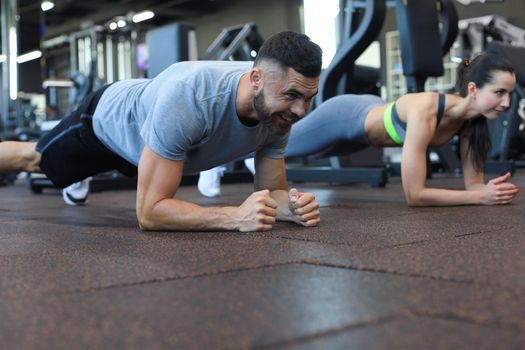 Portrait of beautiful young sports couple on a plank position
